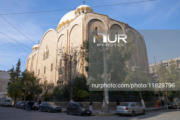 Residents walk near a church in Aleppo, Syria, after the armed opposition takes control of the city, on December 1, 2024.  