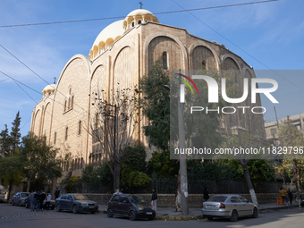 Residents walk near a church in Aleppo, Syria, after the armed opposition takes control of the city, on December 1, 2024.  (