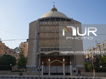 Residents walk near a church in Aleppo, Syria, after the armed opposition takes control of the city, on December 1, 2024.  (