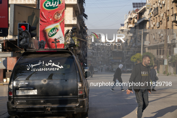 Residents walk near a Christian funeral car in Aleppo, Syria, on December 1, 2024, after the Syrian armed opposition seizes control of the c...