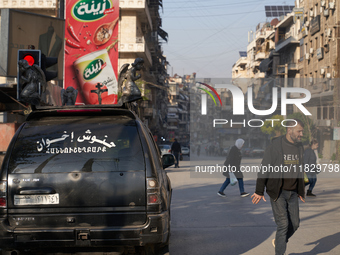 Residents walk near a Christian funeral car in Aleppo, Syria, on December 1, 2024, after the Syrian armed opposition seizes control of the c...