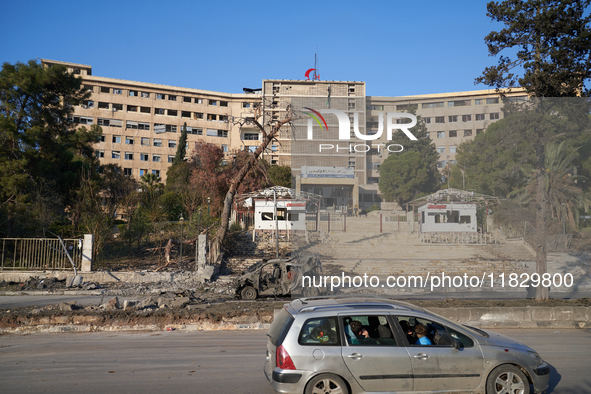 A Syrian family drives past the university hospital, which the Syrian regime targets with airstrikes after opposition forces take control of...