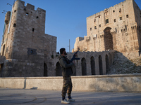 A Syrian armed opposition fighter fires a gun into the air after taking control of the city in Syria on December 1, 2024. (