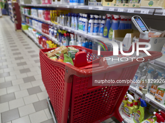 A detailed view of a shopping cart in the aisle of a modern supermarket in Barletta, Italy, on December 1, 2024.   (