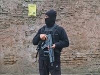 An Indian security personnel stands guard along a road during an encounter on the outskirts of Srinagar, Jammu and Kashmir, on December 3, 2...