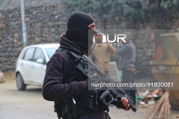 An Indian security personnel stands guard along a road during an encounter on the outskirts of Srinagar, Jammu and Kashmir, on December 3, 2...