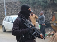 An Indian security personnel stands guard along a road during an encounter on the outskirts of Srinagar, Jammu and Kashmir, on December 3, 2...