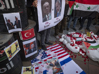 Iranian protesters hold a Syrian flag and an anti-Turkish President placard featuring portraits of the Turkish President and Israeli Prime M...