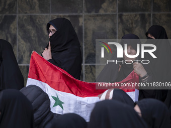 Iranian female protesters hold a flag of Syria while participating in a protest against Turkish President Recep Tayyip Erdogan and his diplo...