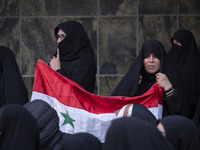 Iranian female protesters hold a flag of Syria while participating in a protest against Turkish President Recep Tayyip Erdogan and his diplo...