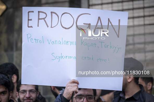 An Iranian protester holds up an anti-Turkish President placard while taking part in a protest against Turkish President Recep Tayyip Erdoga...