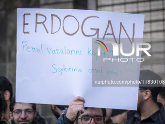 An Iranian protester holds up an anti-Turkish President placard while taking part in a protest against Turkish President Recep Tayyip Erdoga...