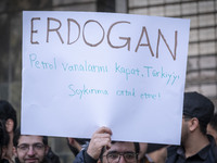 An Iranian protester holds up an anti-Turkish President placard while taking part in a protest against Turkish President Recep Tayyip Erdoga...