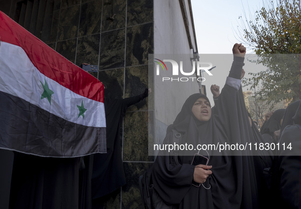 A female Iranian protester holds a flag of Syria as another veiled protester shouts anti-Turkish President slogans. They participate in a pr...