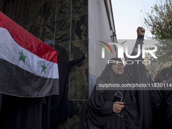 A female Iranian protester holds a flag of Syria as another veiled protester shouts anti-Turkish President slogans. They participate in a pr...