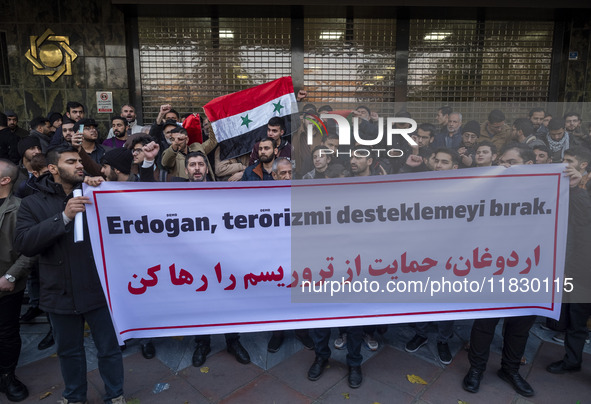 Iranian protesters hold a flag of Syria and an anti-Turkish placard while taking part in a protest against Turkish President Recep Tayyip Er...