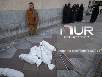 Packages wrapped in shrouds symbolizing the bodies of people of Syria are placed on a sidewalk during a protest against Turkish President Re...