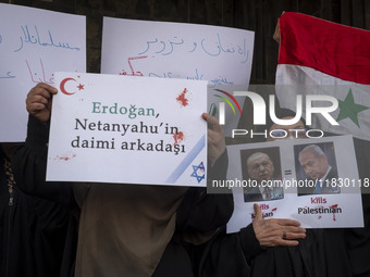 Iranian female protesters hold a flag of Syria and anti-Turkish President placards during a protest against Turkish President Recep Tayyip E...