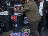 Copies of the U.S. Dollar and Turkish Lira banknotes, along with a poster featuring portraits of Turkish President Recep Tayyip Erdogan and...