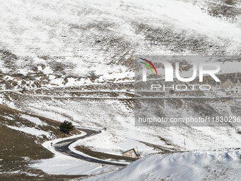 A winding road through snowy hills is seen in Campo Imperatore, Gran Sasso d'Italia, Italy, on November 16, 2024.  (