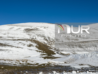 A winding road through snowy hills is seen in Campo Imperatore, Gran Sasso d'Italia, Italy, on November 16, 2024.  (