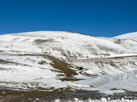 A winding road through snowy hills is seen in Campo Imperatore, Gran Sasso d'Italia, Italy, on November 16, 2024.  (