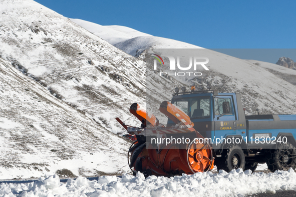 A snowplow clears freshly fallen snow against a backdrop of snowy hills in Campo Imperatore, Gran Sasso d'Italia, Italy, on November 16, 202...