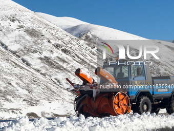 A snowplow clears freshly fallen snow against a backdrop of snowy hills in Campo Imperatore, Gran Sasso d'Italia, Italy, on November 16, 202...