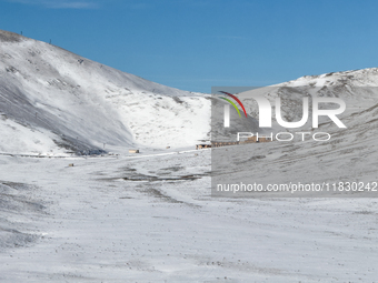   A snow-covered plateau with a mountain lodge nestled in the valley is seen in Campo Imperatore, Gran Sasso d'Italia, Italy, on November 16...