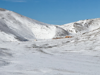   A snow-covered plateau with a mountain lodge nestled in the valley is seen in Campo Imperatore, Gran Sasso d'Italia, Italy, on November 16...