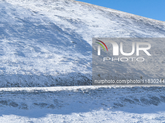 A winding road through snowy hills is seen in Campo Imperatore, Gran Sasso d'Italia, Italy, on November 16, 2024.  (