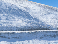 A winding road through snowy hills is seen in Campo Imperatore, Gran Sasso d'Italia, Italy, on November 16, 2024.  (