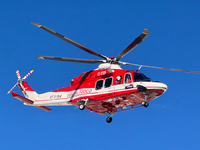 A rescue helicopter from Vigili del Fuoco hovers in a clear blue sky above Campo Imperatore, Gran Sasso d'Italia, Italy, on November 16, 202...