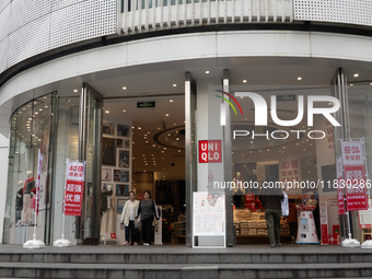 Customers pass by Uniqlo's global flagship store as it celebrates its 40th anniversary in Shanghai, China, on December 3, 2024. (