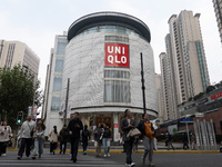 Customers pass by Uniqlo's global flagship store as it celebrates its 40th anniversary in Shanghai, China, on December 3, 2024. (