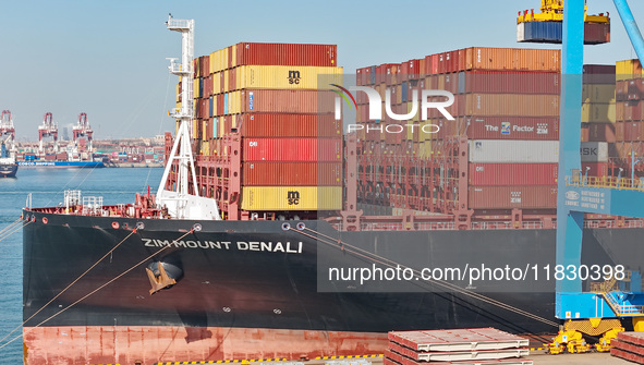 A cargo ship loads and unloads cargo at the fully automated terminal of Qingdao Port in Qingdao, China, on December 3, 2024. 