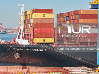 A cargo ship loads and unloads cargo at the fully automated terminal of Qingdao Port in Qingdao, China, on December 3, 2024. (