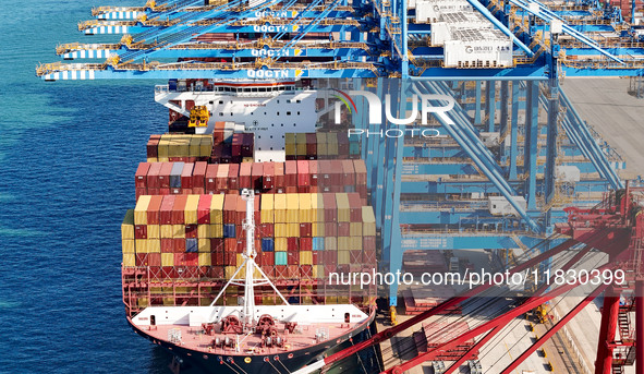 A cargo ship loads and unloads cargo at the fully automated terminal of Qingdao Port in Qingdao, China, on December 3, 2024. 