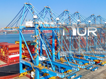 A cargo ship loads and unloads cargo at the fully automated terminal of Qingdao Port in Qingdao, China, on December 3, 2024. (