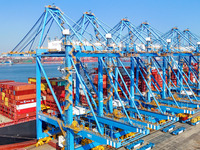 A cargo ship loads and unloads cargo at the fully automated terminal of Qingdao Port in Qingdao, China, on December 3, 2024. (