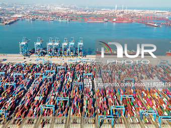 Several freighters load and unload cargo at the fully automated terminal of Qingdao Port in Qingdao, China, on December 3, 2024. (