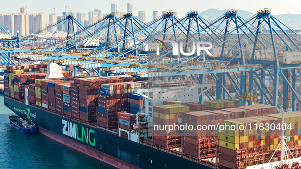 A cargo ship loads and unloads cargo at the fully automated terminal of Qingdao Port in Qingdao, China, on December 3, 2024. 