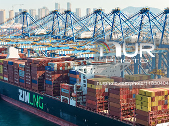 A cargo ship loads and unloads cargo at the fully automated terminal of Qingdao Port in Qingdao, China, on December 3, 2024. (