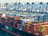 A cargo ship loads and unloads cargo at the fully automated terminal of Qingdao Port in Qingdao, China, on December 3, 2024. (