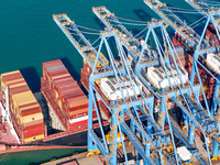 A cargo ship loads and unloads cargo at the fully automated terminal of Qingdao Port in Qingdao, China, on December 3, 2024. (