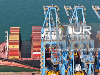 A cargo ship loads and unloads cargo at the fully automated terminal of Qingdao Port in Qingdao, China, on December 3, 2024. (