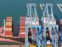 A cargo ship loads and unloads cargo at the fully automated terminal of Qingdao Port in Qingdao, China, on December 3, 2024. (