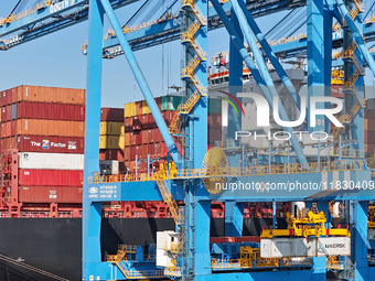 A cargo ship loads and unloads cargo at the fully automated terminal of Qingdao Port in Qingdao, China, on December 3, 2024. (