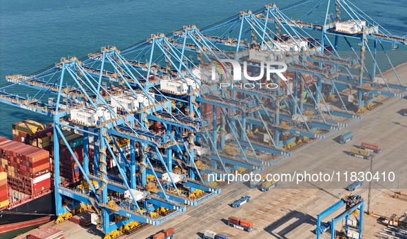 A cargo ship loads and unloads cargo at the fully automated terminal of Qingdao Port in Qingdao, China, on December 3, 2024. 