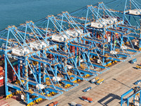 A cargo ship loads and unloads cargo at the fully automated terminal of Qingdao Port in Qingdao, China, on December 3, 2024. (